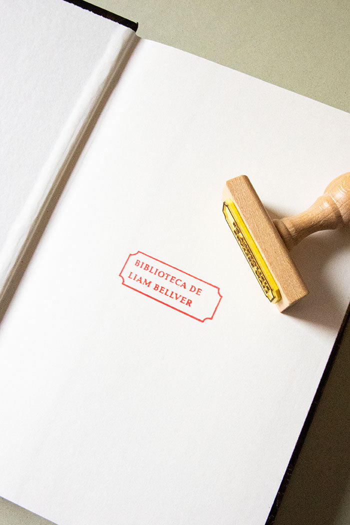Portadilla de libro estampada con una etiqueta con el nombre de su proprietario y sello