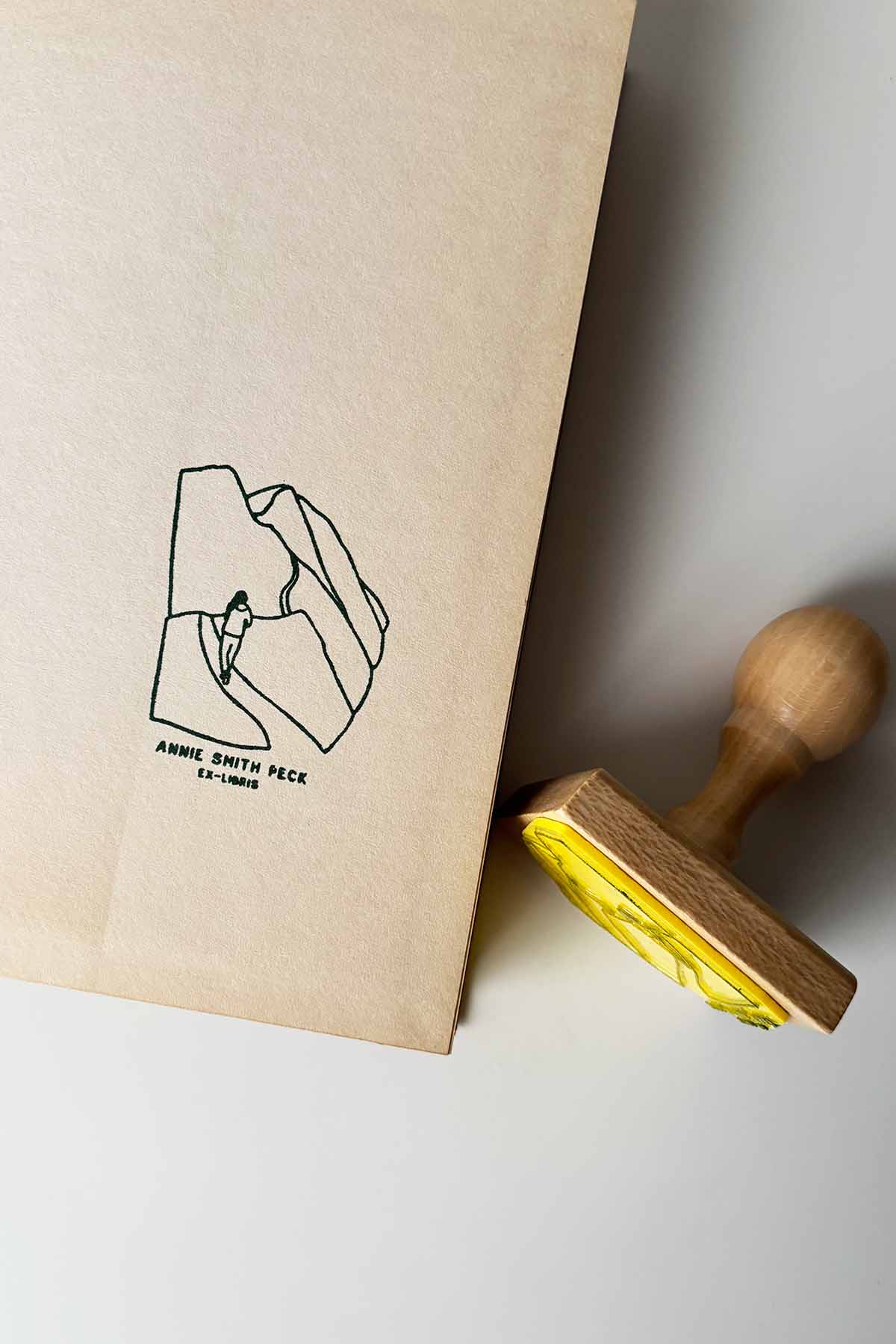 Portadilla de libro estampada con una chica andando por un camino de montaña y sello