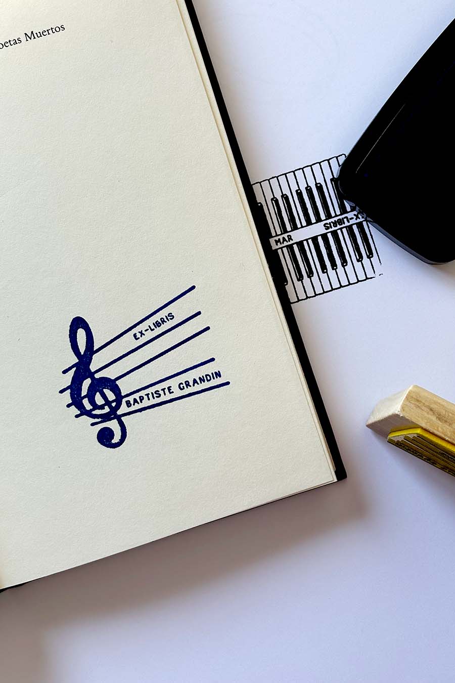 Portadilla de libro estampado con sello exlibris con clave de sol y pentagrama y sello