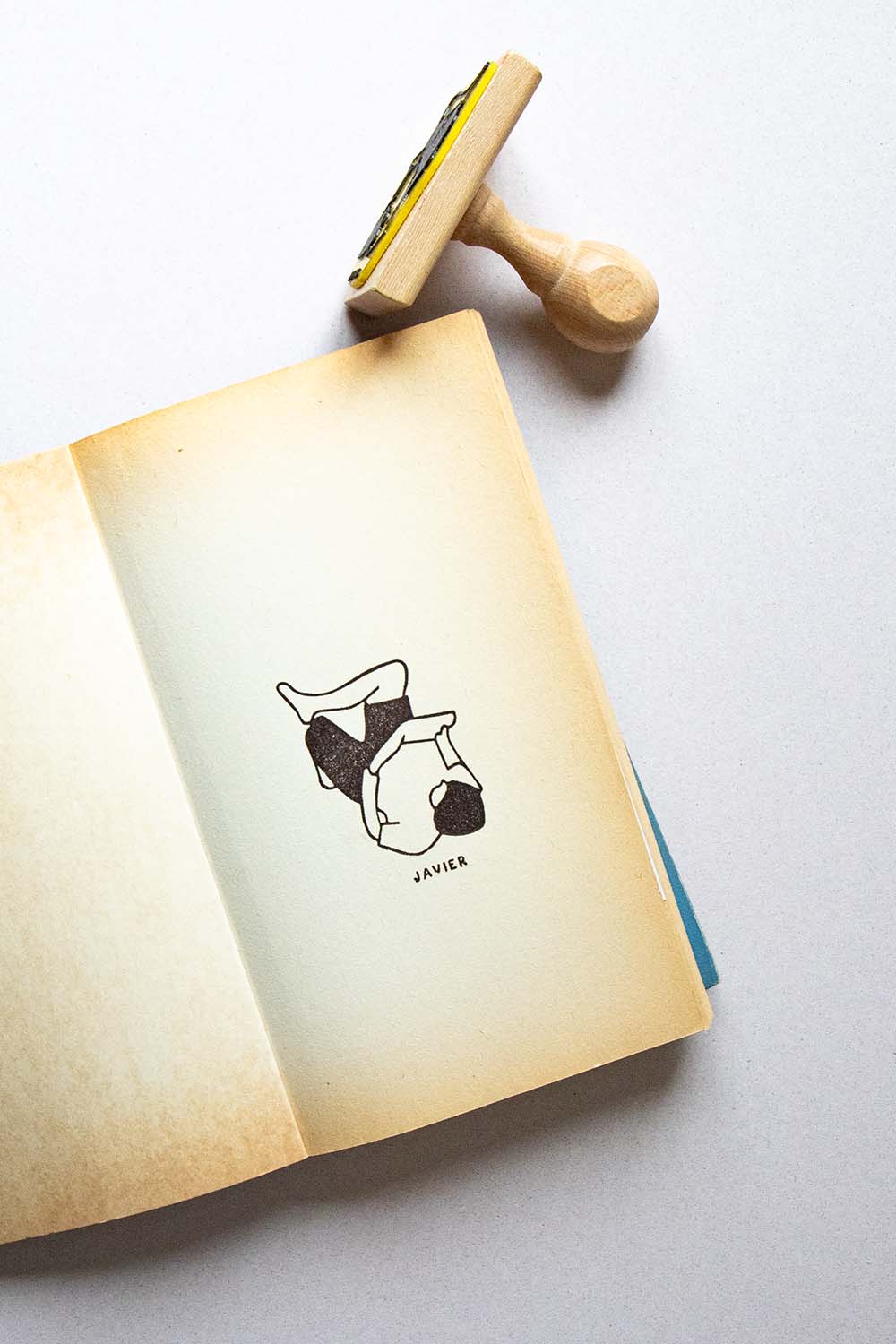 Portadilla de libro estampado con una persona tumbada leyendo relajada con las rodillas y sello