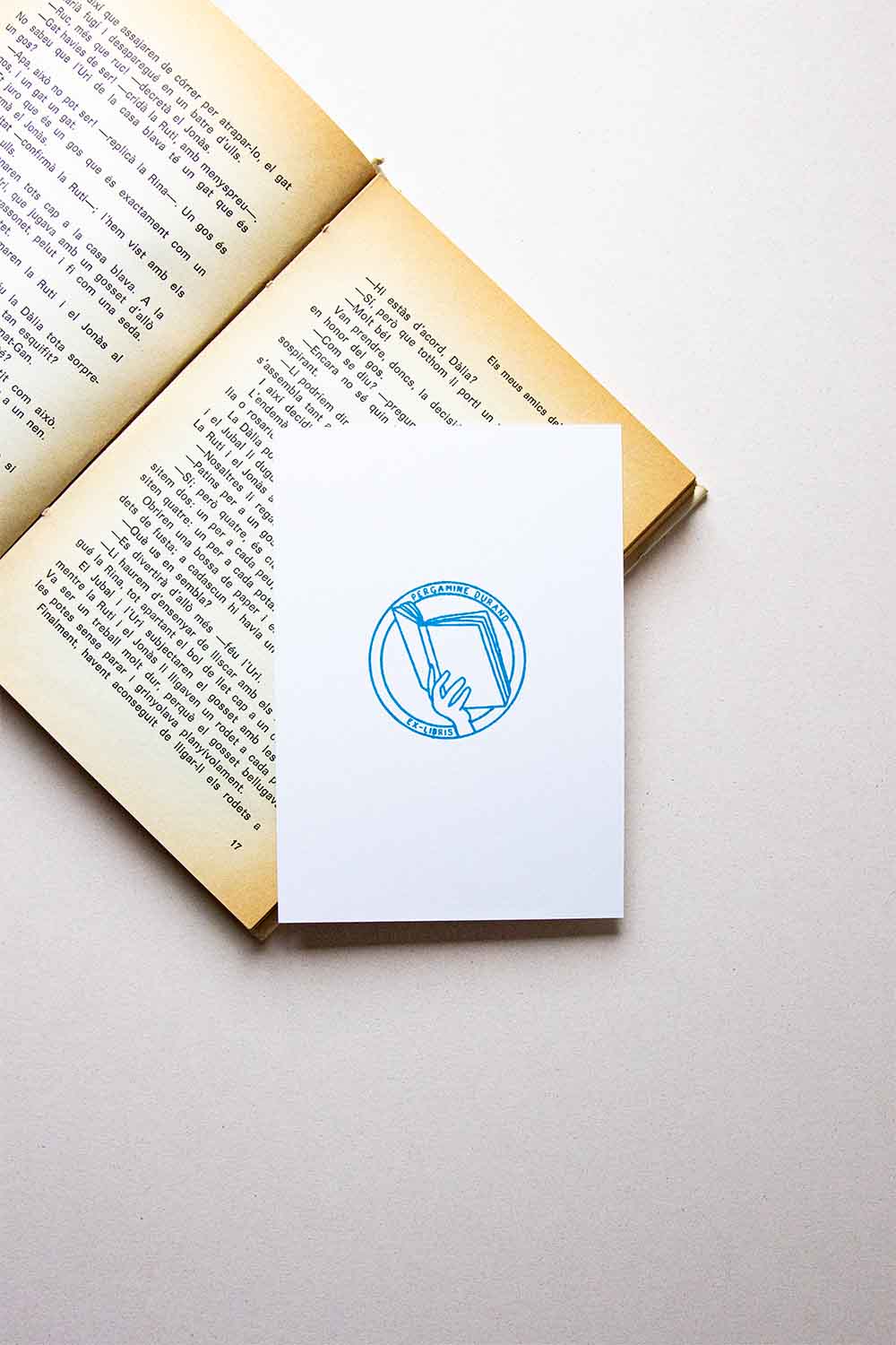 Portadilla de libro estampada con una mano sosteniendo un libro