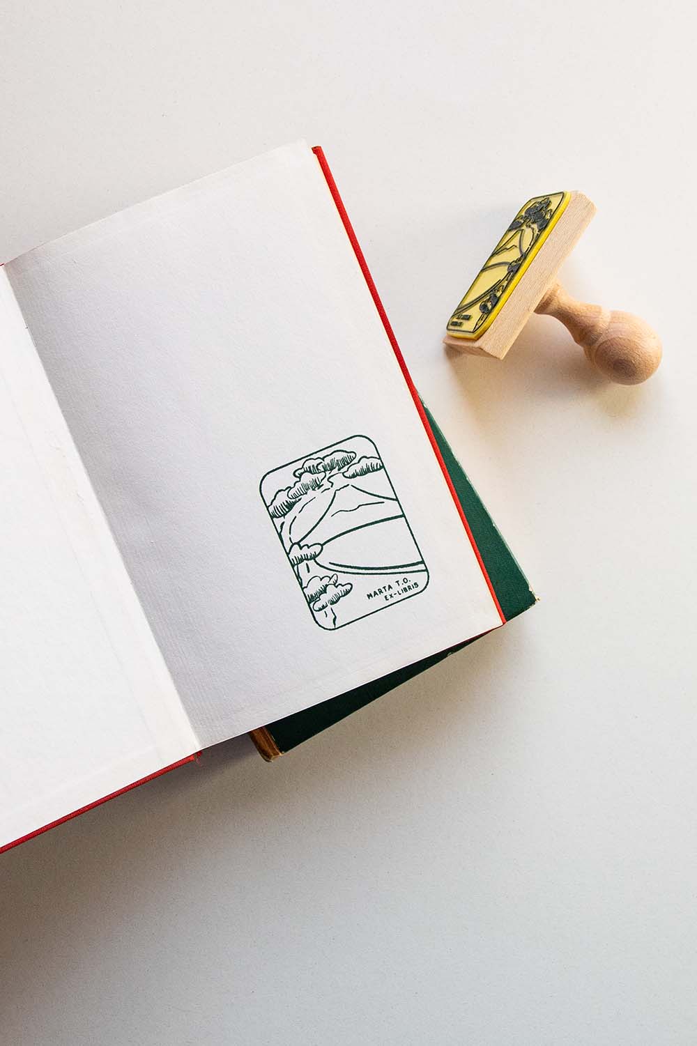 Portadilla de libro estampada con sello exlibris del monte Fuji enmarcado por un árbol y sello