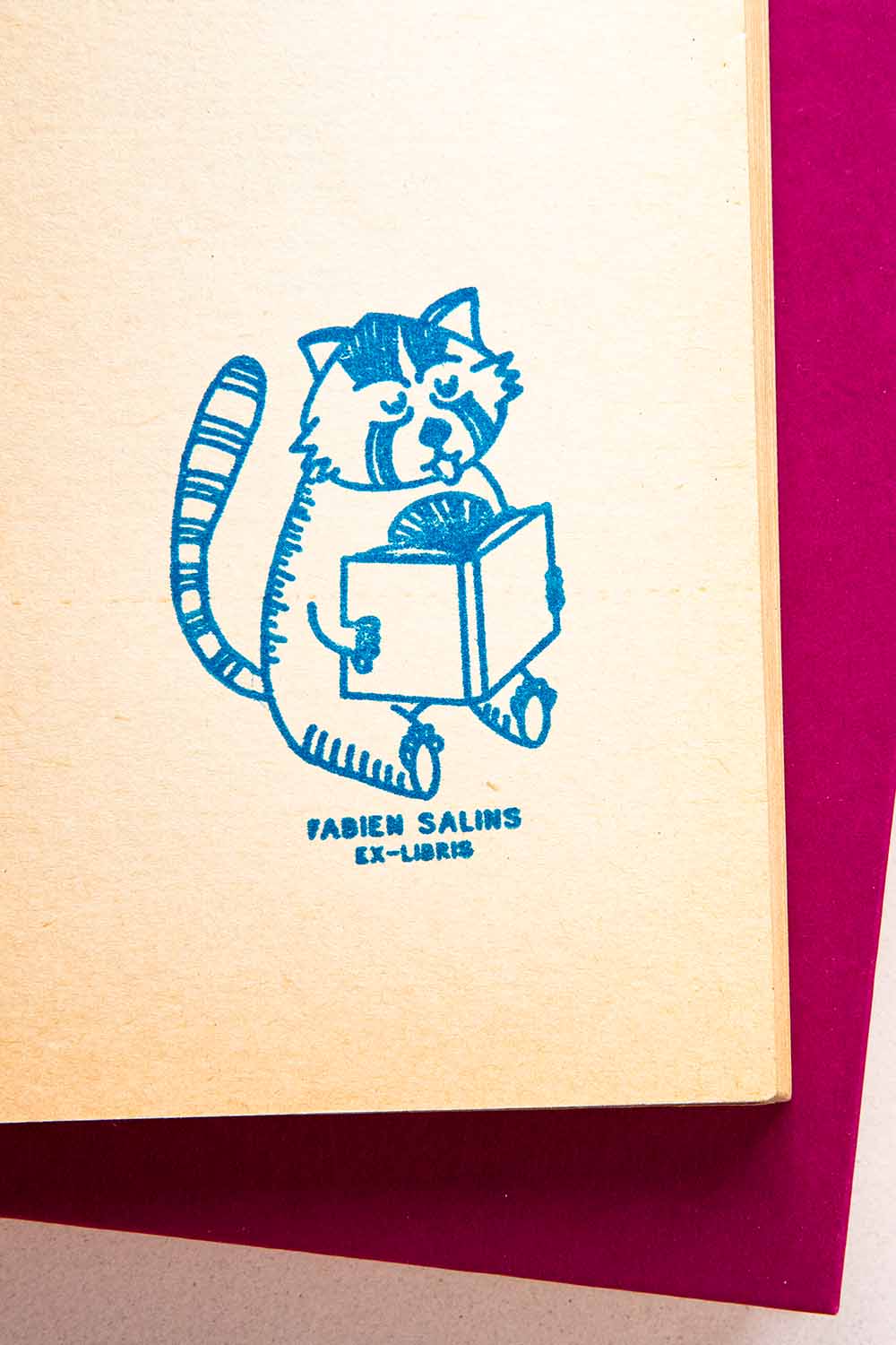 Portadilla de libro estampada con sello exlibris de un panda rojo leyendo