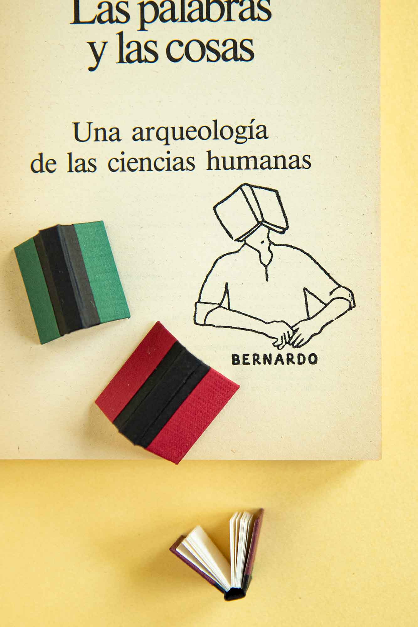 Portadilla de libro estampada con un sello exlibris de una persona dormiendo con un libro abierto encima de su cara