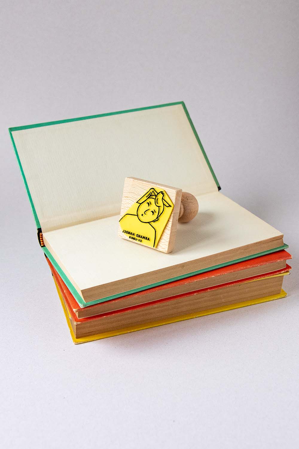 Sello exlibris grabado de un hombre sorprendido con un mechón de pelo hacia arriba y un libro sobre su cabeza