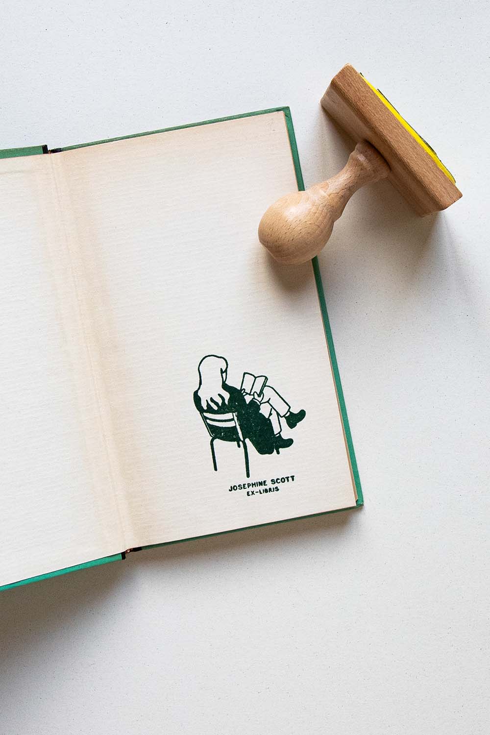 Portadilla de libro estampado con una persona leyendo en las sillas de un parque de París y sello