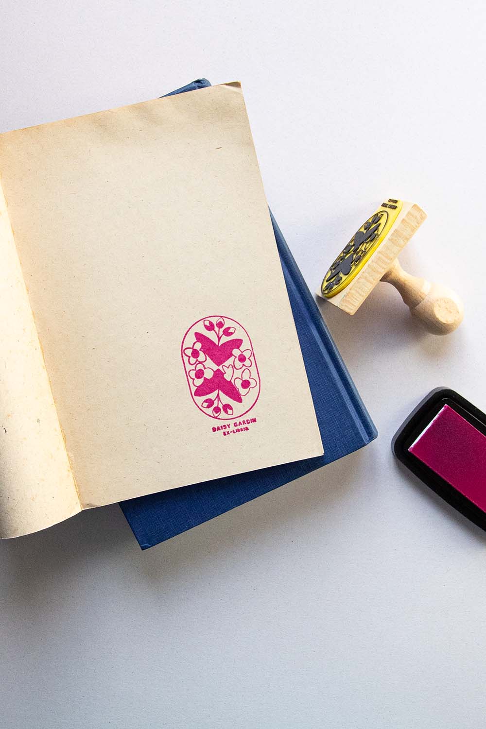 Portadilla de libro estampado con un motivo floral enmarcado en un recuadro con esquinas redondas y sello