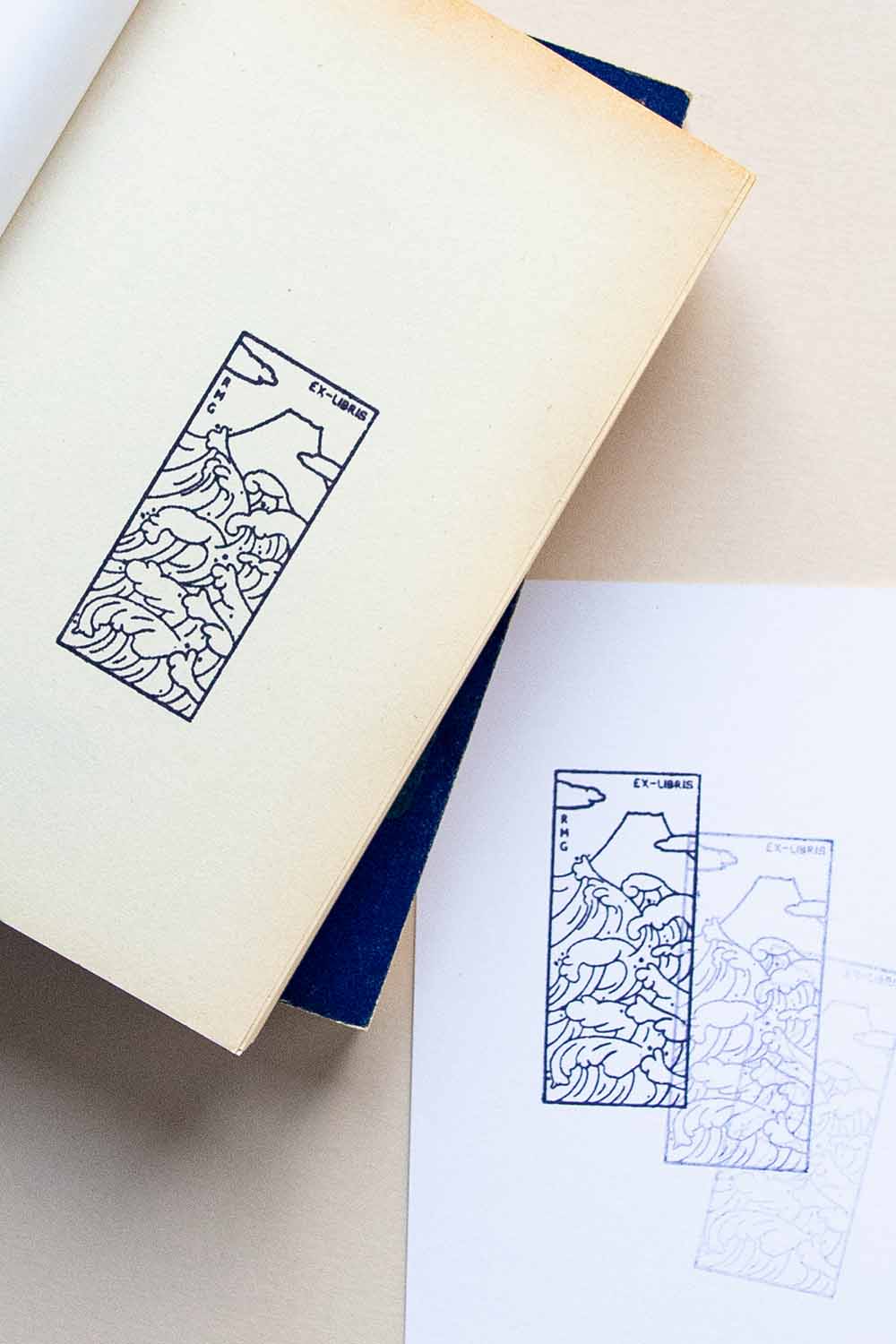 Portadilla de libro estampada con sello exlibris de olas y al fondo el monte Fuji