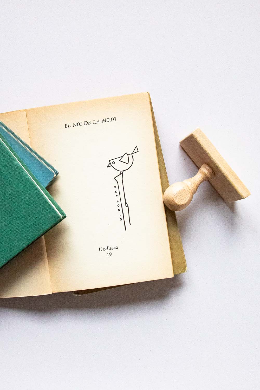 Portadilla de libro estampada con sello exlibris de un pájaro encima de un palo y sello