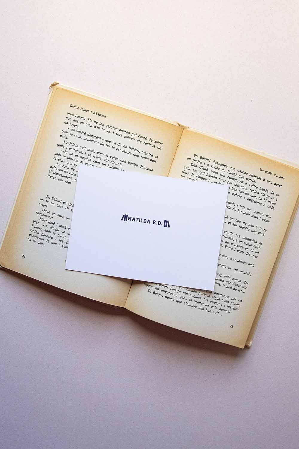 Portadilla de libro estampada con sellos exlibris de un dibujo de pilas de libros