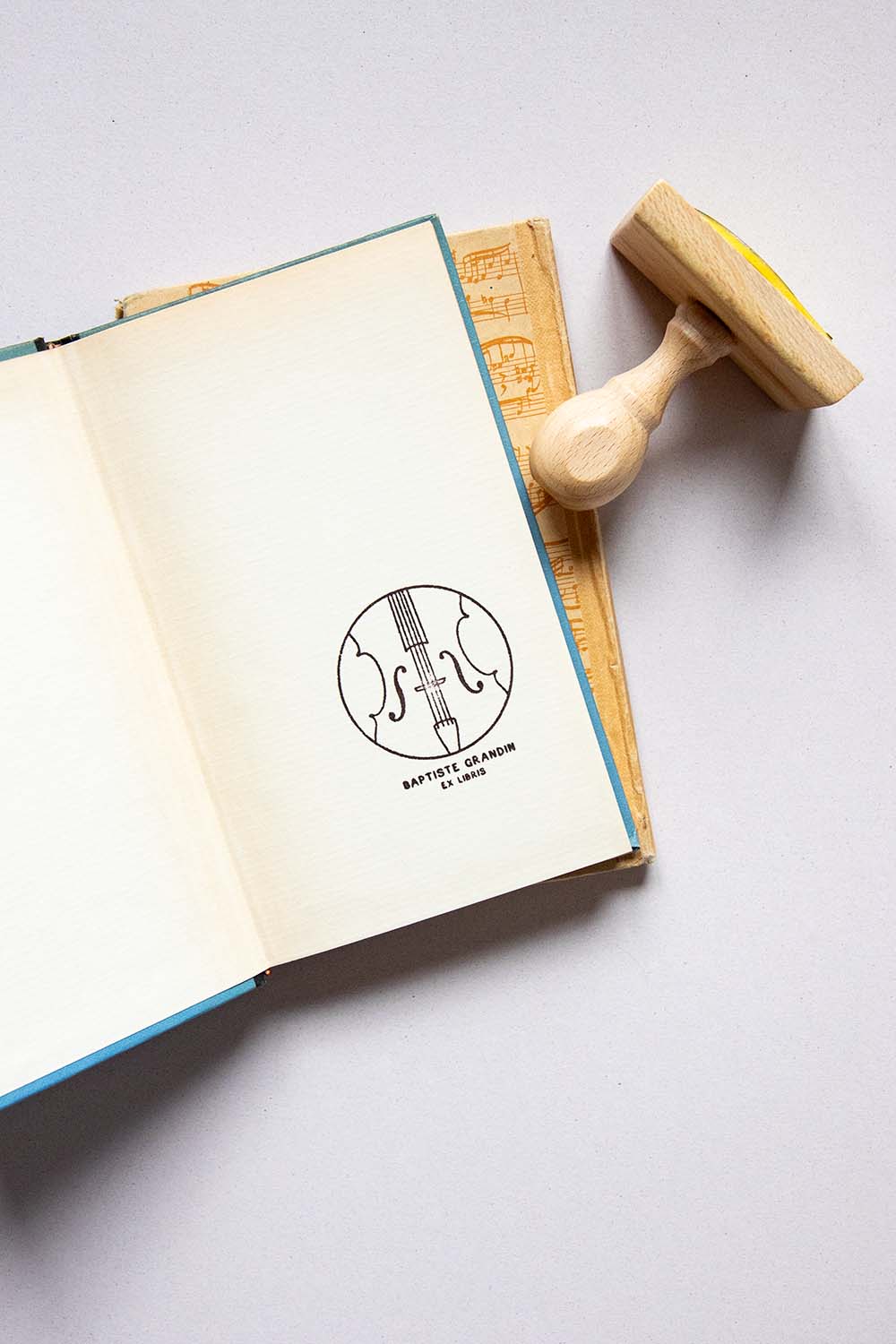 Portadilla de libro estampado con sello exlibris de violín y sello