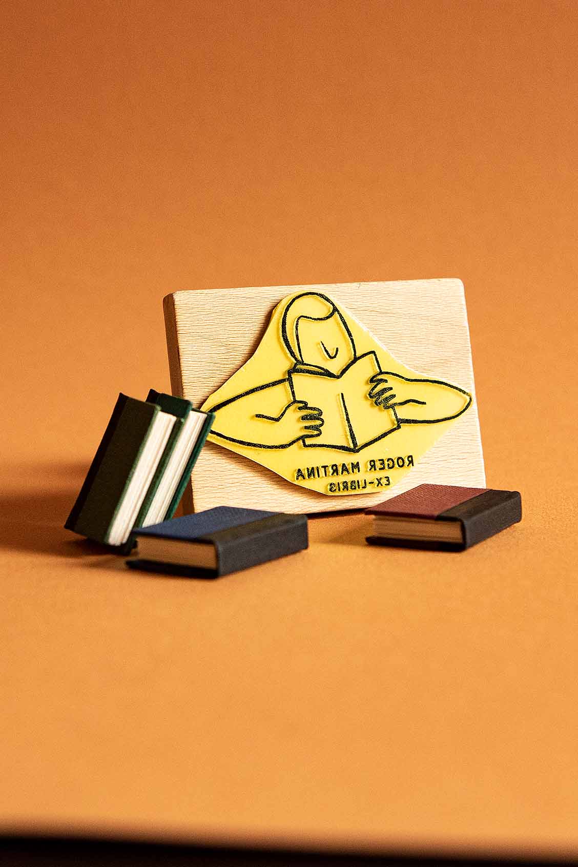 Sello exlibris grabado de un lector absorto en la lectura de un libro