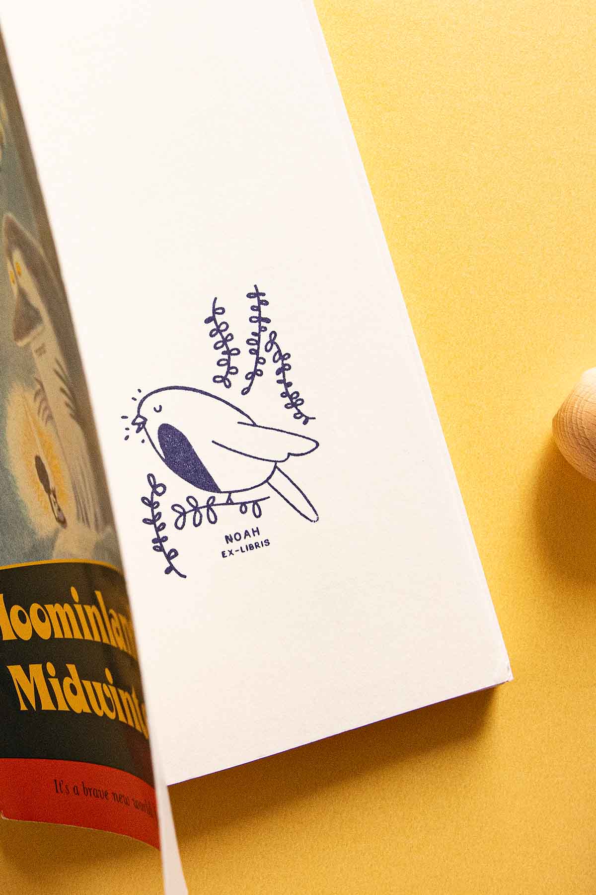 Portadilla de libro estampada con sello exlibris de un pájaro petirrojo cantando